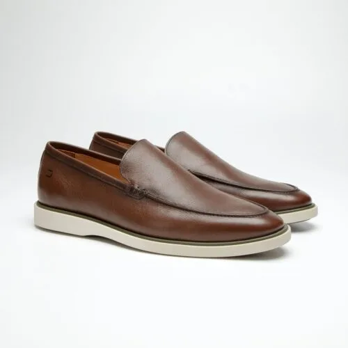 par de sapatos douss bourbon de couro marrom, sem cadarço modelo slip on, palmilha de couro marrom claro com a escrita douss e solado de borracha branca visto de lado na diagonal
