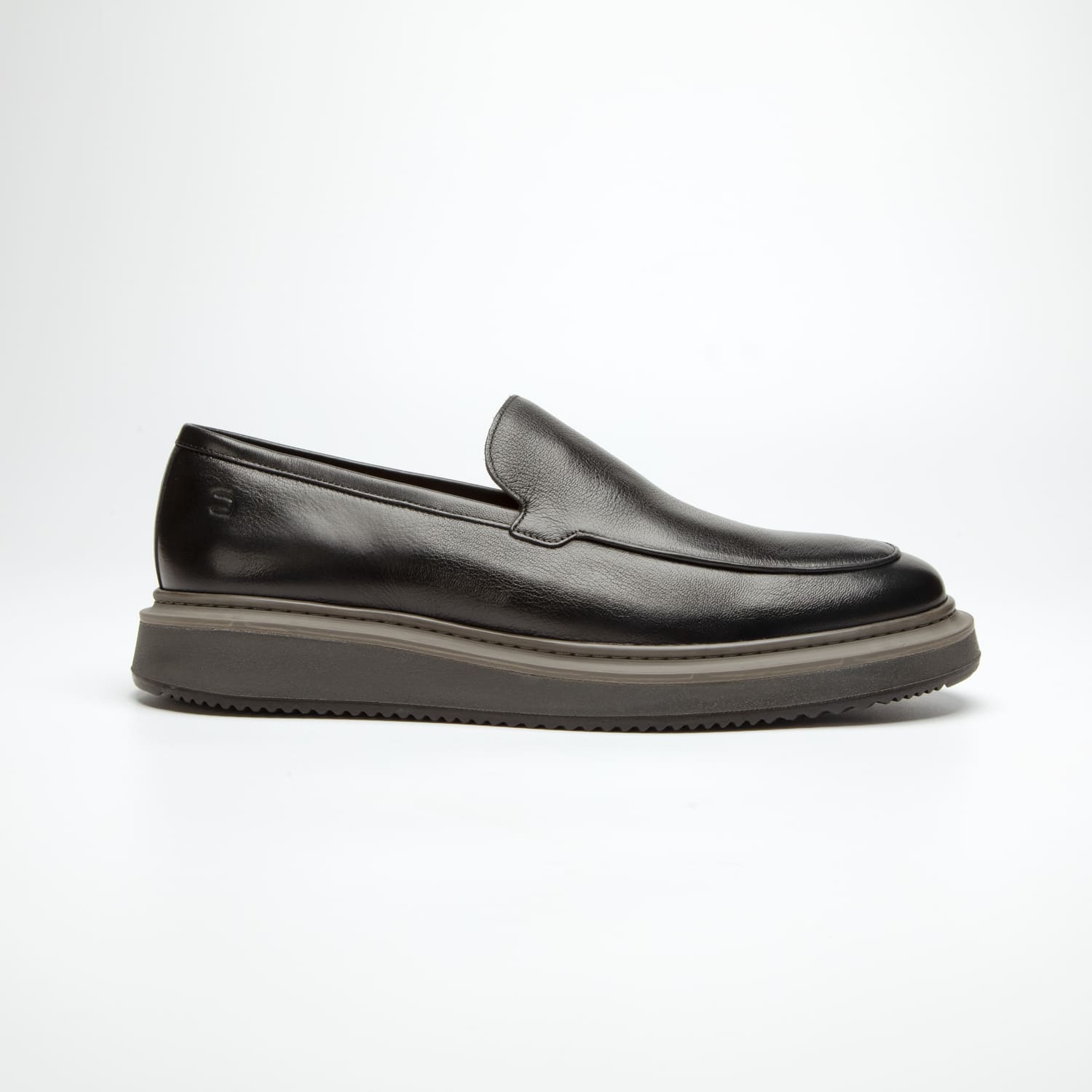 pé do sapato mocassim douss brooklin em couro preto, sem cadarços, estilo slip on, com solado cinza escuro visto de lado