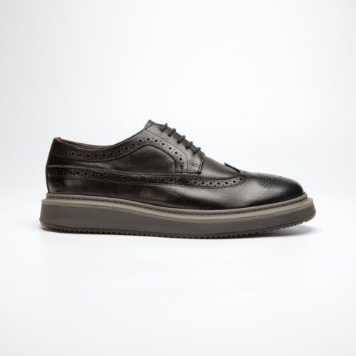 pé do sapato douss melbourne em couro preto, furado no estilo brogue, cadarços finos na cor do couro, com solado alto com as cores cinza escuro e preto visto de lado