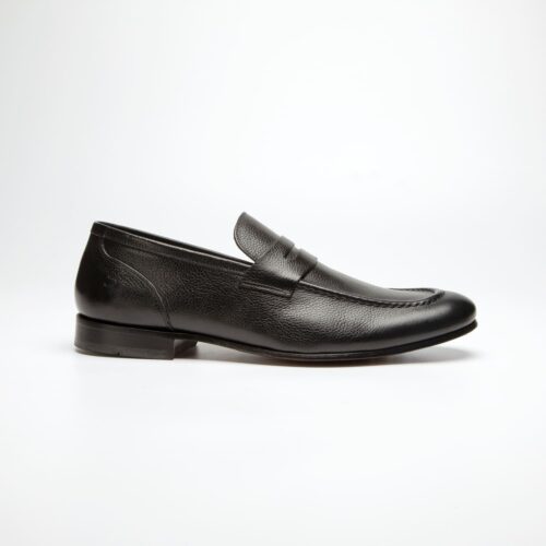 pé do sapato douss royalle estilo mocassim em couro preto, sem cadarços, com gravata frontal preta, solado e salto preto visto de lado