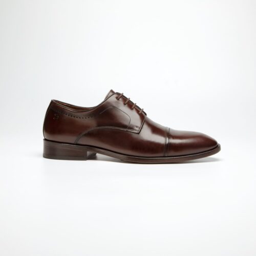 pé do sapato social douss spiga estilo derby, couro marrom escuro com furos como detalhes, cadarços finos na cor marrom escura, solado e salto na cor marrom escura visto de lado