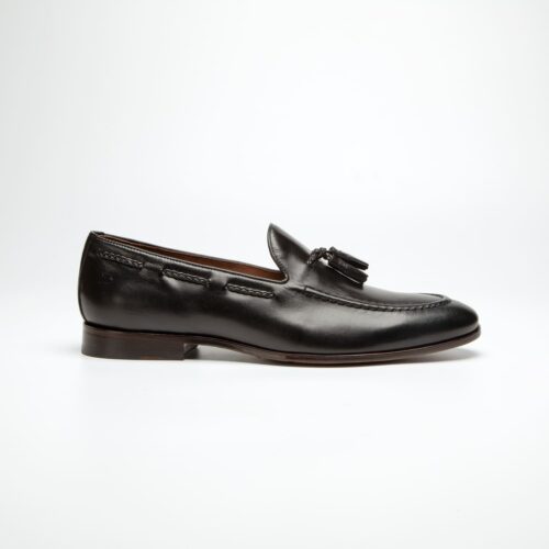 pé do sapato douss veneto em couro preto estilo mocassim com detalhes de cordão nas laterais na cor preto e na parte da frente uma gravata bambolim e solado na cor preta visto de lado